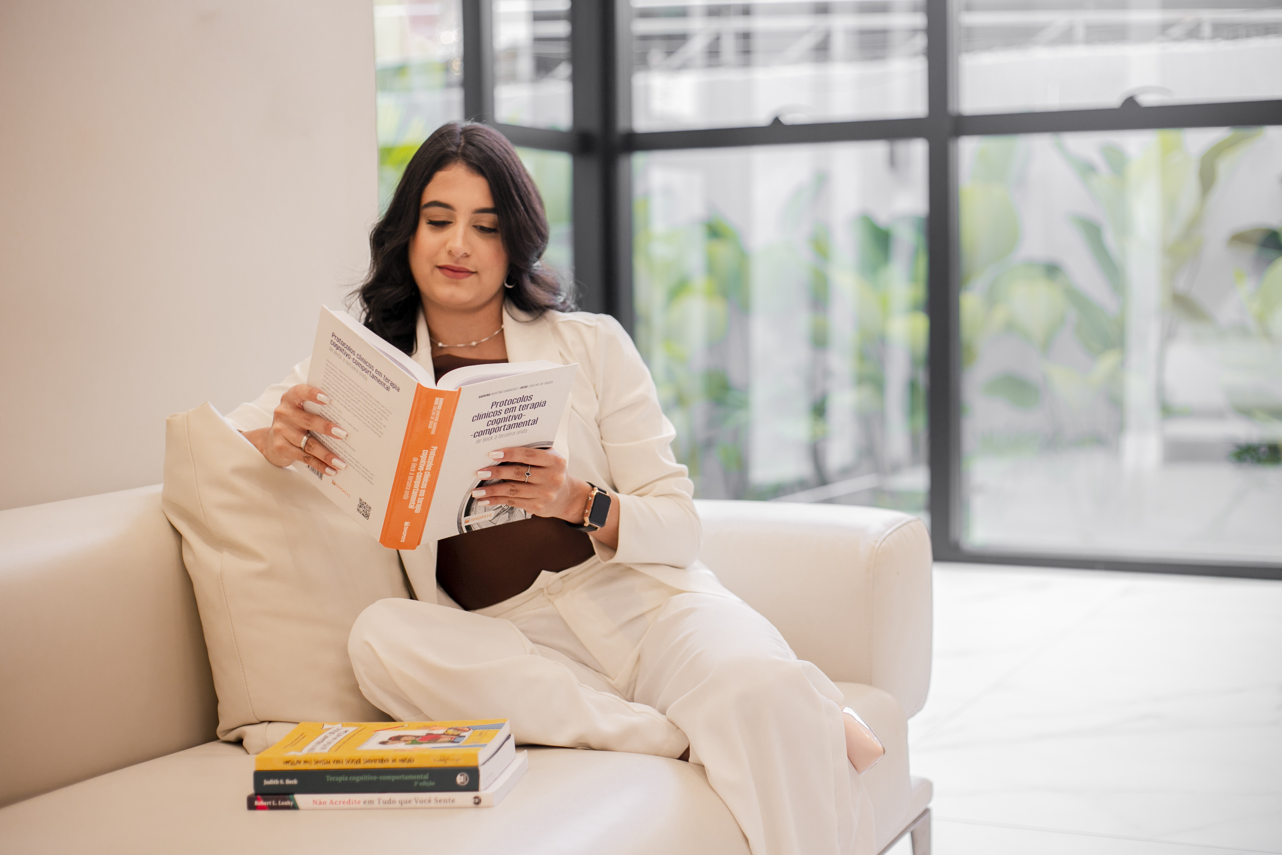 Thaise Cristinne lendo em um ambiente acolhedor